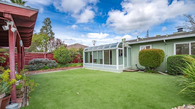 view of yard featuring fence private yard and a sunroom