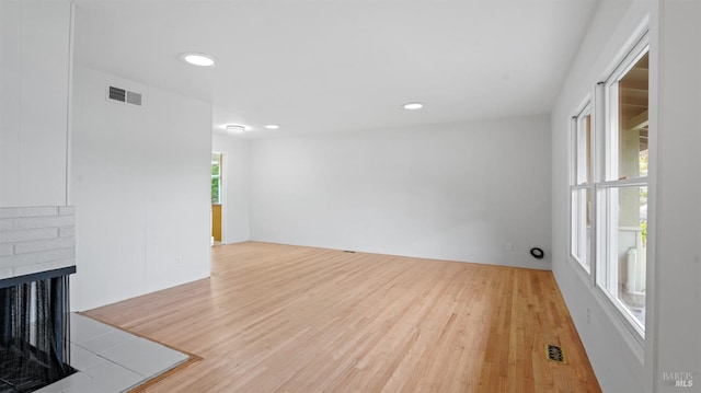 unfurnished living room with light wood-style flooring, visible vents, a fireplace, and recessed lighting