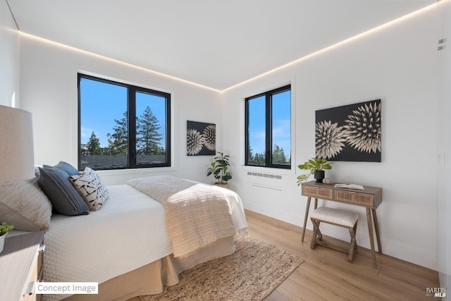bedroom featuring baseboards and light wood finished floors