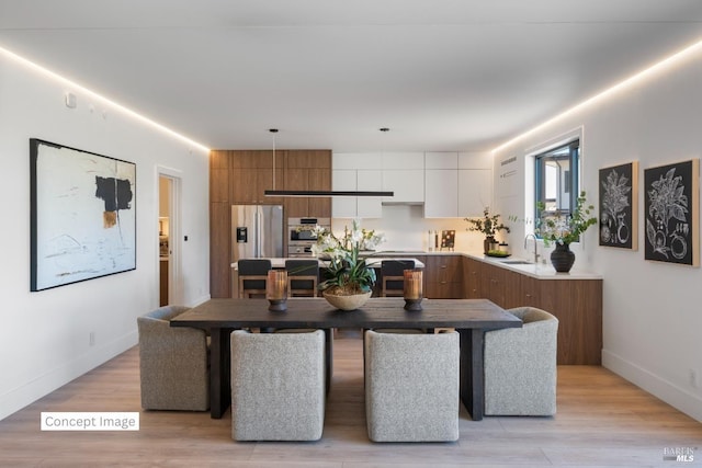 dining space featuring baseboards and light wood finished floors