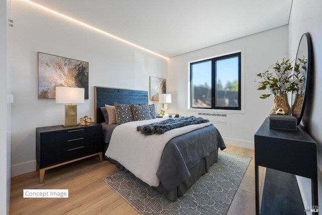 bedroom featuring baseboards and wood finished floors