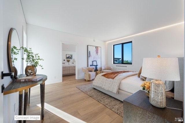 bedroom featuring ensuite bathroom, baseboards, and light wood-style floors