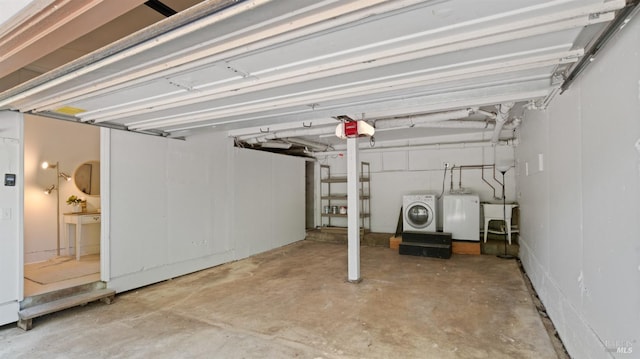 garage featuring independent washer and dryer, a garage door opener, and a sink