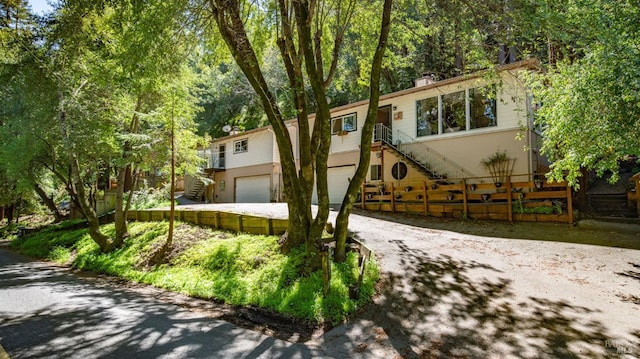 view of front of home featuring stairway, driveway, and a garage