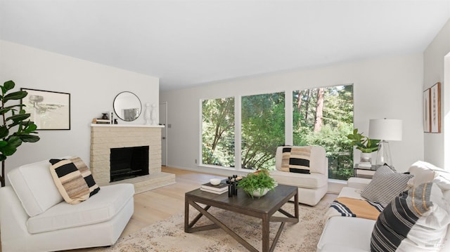 living room with light wood-type flooring and a brick fireplace