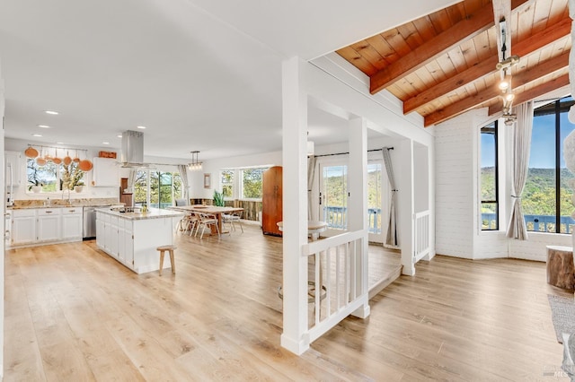 living room featuring light wood-style flooring, a wealth of natural light, and beam ceiling