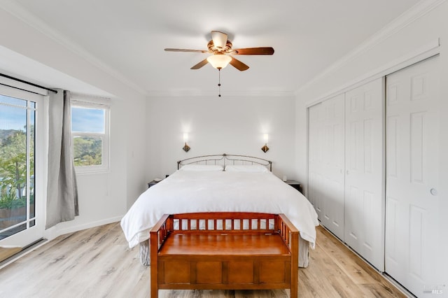 bedroom featuring ceiling fan, light wood-style floors, a closet, and crown molding