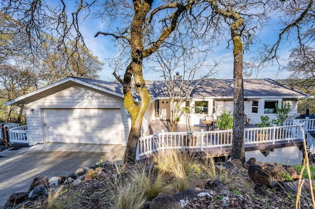 single story home featuring a deck and a garage