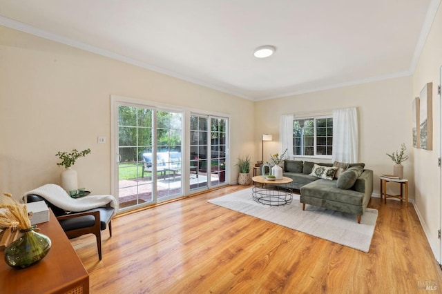 living area with ornamental molding, baseboards, and wood finished floors