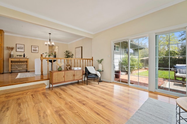 living area featuring crown molding, baseboards, a chandelier, and light wood-type flooring