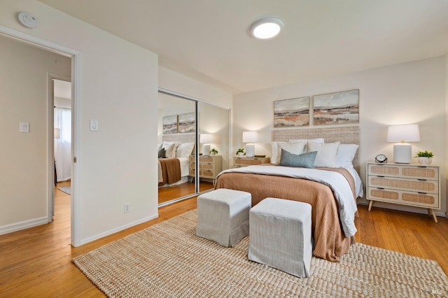 bedroom featuring baseboards, a closet, and wood finished floors