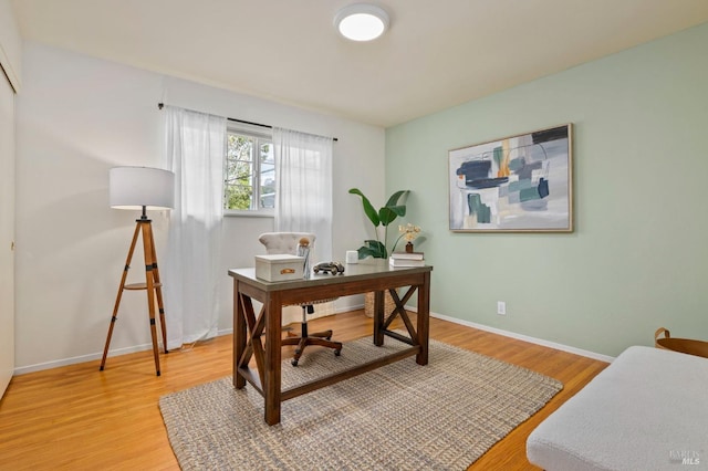 office area featuring light wood finished floors and baseboards