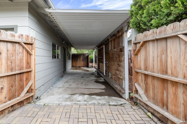 view of patio with an outbuilding, an exterior structure, and a carport