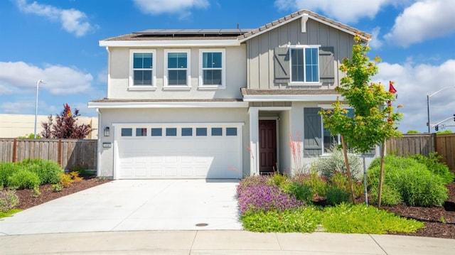 1096 Fiano Pl, Manteca, CA 95337 - view of front of home with fence, solar panels, an attached garage, driveway, and board and batten siding