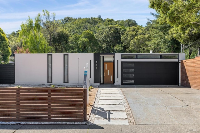 view of front of property featuring a gate, fence, and a garage