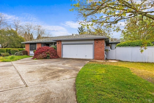 view of front of house featuring a front lawn, fence, brick siding, concrete driveway, and an attached garage