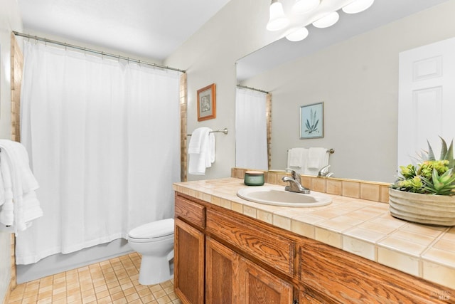 bathroom featuring vanity, tile patterned flooring, and toilet