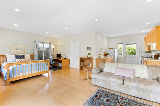 bedroom featuring recessed lighting, freestanding refrigerator, and light wood-type flooring