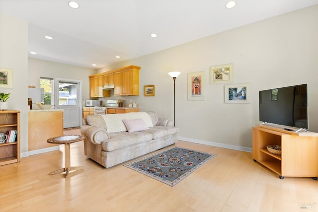living room featuring recessed lighting, baseboards, and light wood-type flooring