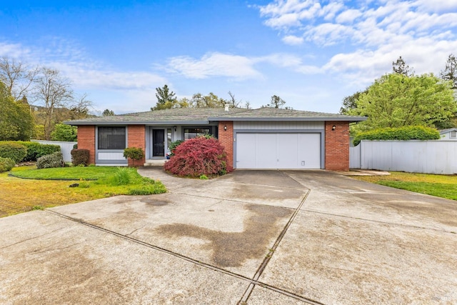 ranch-style house featuring brick siding, fence, driveway, and a garage