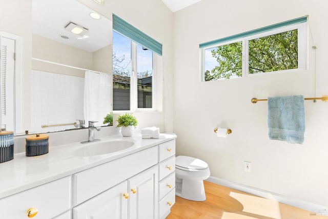 bathroom with vanity, toilet, baseboards, curtained shower, and wood finished floors