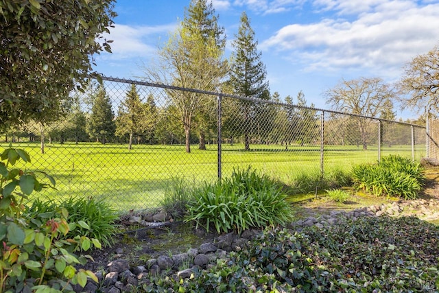 surrounding community with fence and a yard