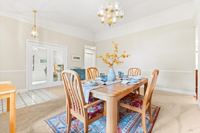 dining room with light tile patterned flooring, an inviting chandelier, light carpet, french doors, and lofted ceiling