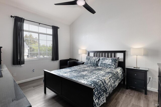 bedroom featuring lofted ceiling, wood finished floors, ceiling fan, and baseboards