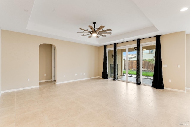 8568 Pinehollow Cir, Discovery Bay, CA 94505 - spare room featuring a tray ceiling, arched walkways, baseboards, a ceiling fan, and recessed lighting