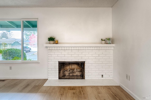 6574 Stone Bridge Rd, Santa Rosa, CA 95409 - details featuring baseboards, a textured ceiling, wood finished floors, and a brick fireplace