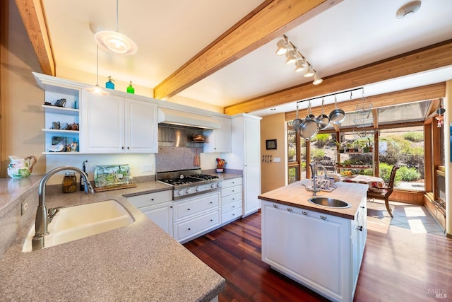 kitchen with white cabinetry, stovetop, and a sink