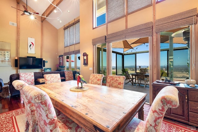 dining space with high vaulted ceiling, visible vents, and wood finished floors