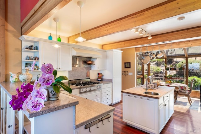kitchen with white cabinets, a sink, open shelves, and beamed ceiling