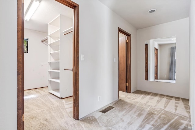 hall featuring carpet and visible vents