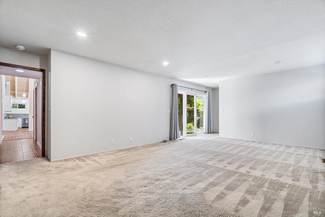 spare room with carpet floors, recessed lighting, and a textured ceiling