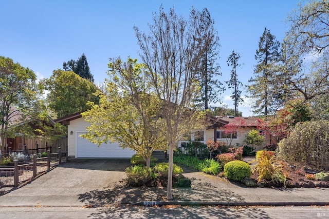 view of front of property with concrete driveway, fence, and an attached garage