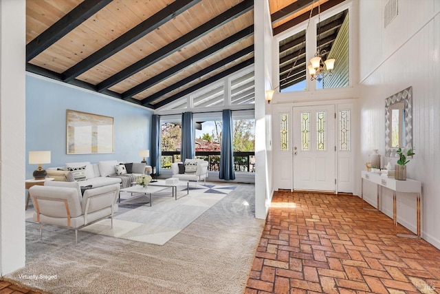 entrance foyer featuring an inviting chandelier, high vaulted ceiling, beam ceiling, brick floor, and visible vents