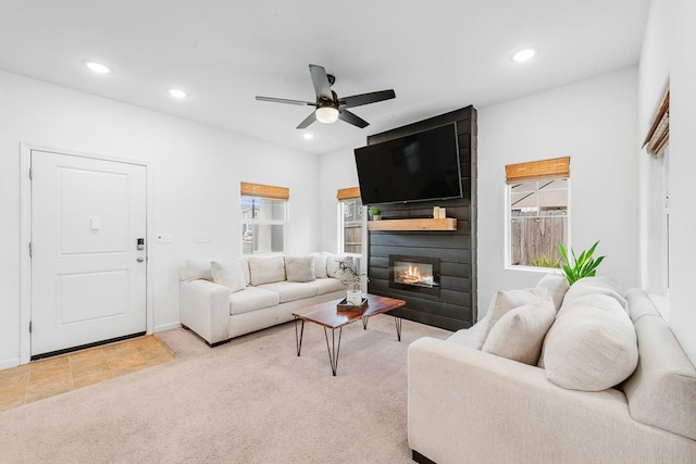 living room with recessed lighting, a ceiling fan, light carpet, and a fireplace