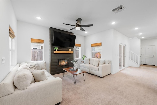 living area with ceiling fan, light colored carpet, visible vents, a fireplace, and recessed lighting