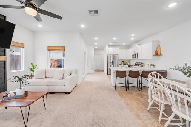 living area featuring ceiling fan, recessed lighting, and visible vents