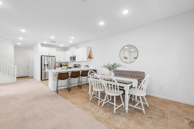dining area featuring recessed lighting, baseboards, stone finish floor, and stairway