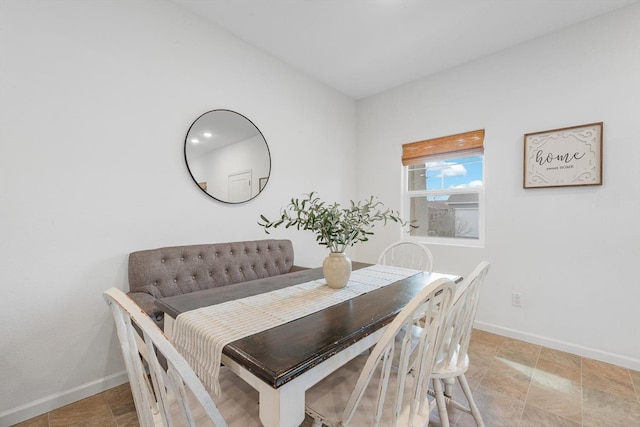 dining space with baseboards and stone finish flooring