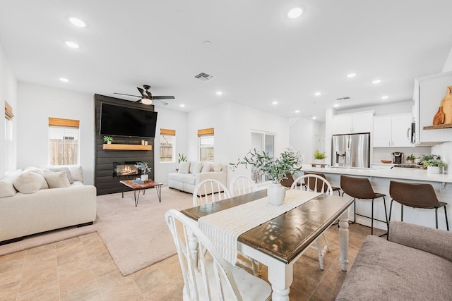 dining space featuring a fireplace, a ceiling fan, recessed lighting, and visible vents