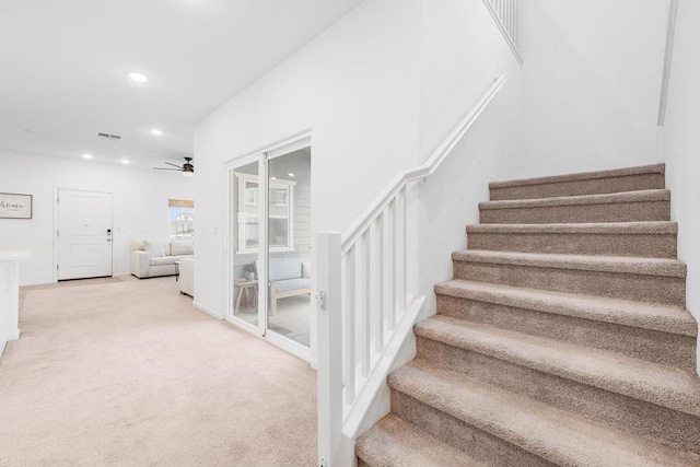 stairs with recessed lighting, a ceiling fan, carpet flooring, and visible vents