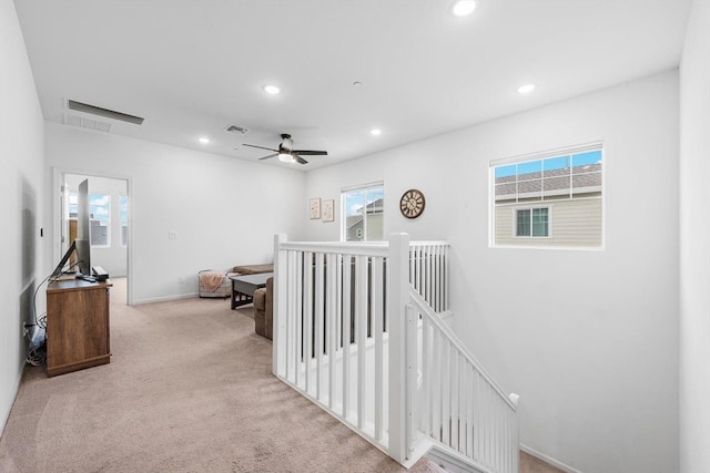 hallway with visible vents, carpet floors, baseboards, an upstairs landing, and recessed lighting