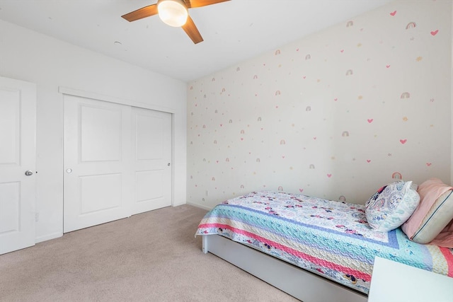 bedroom featuring carpet flooring, ceiling fan, wallpapered walls, and a closet