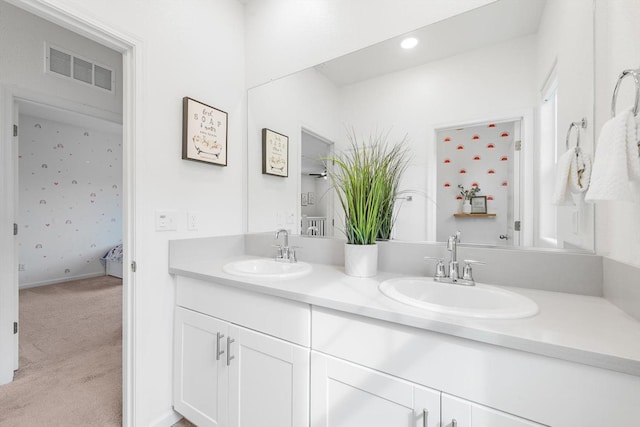 full bath with a sink, double vanity, and visible vents