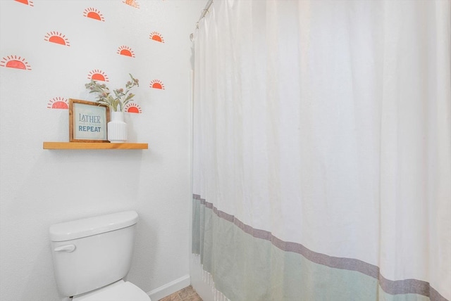 bathroom featuring toilet and baseboards
