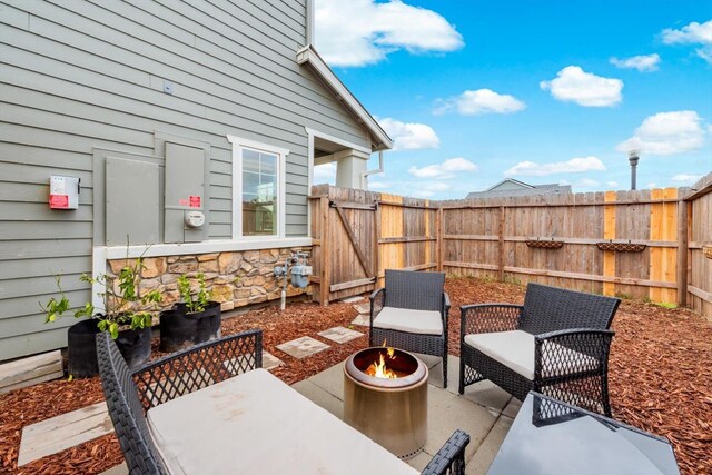 view of patio / terrace featuring a fenced backyard, a gate, and an outdoor fire pit