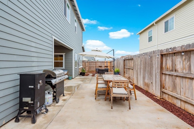 view of patio / terrace with outdoor dining area, a fenced backyard, and a grill